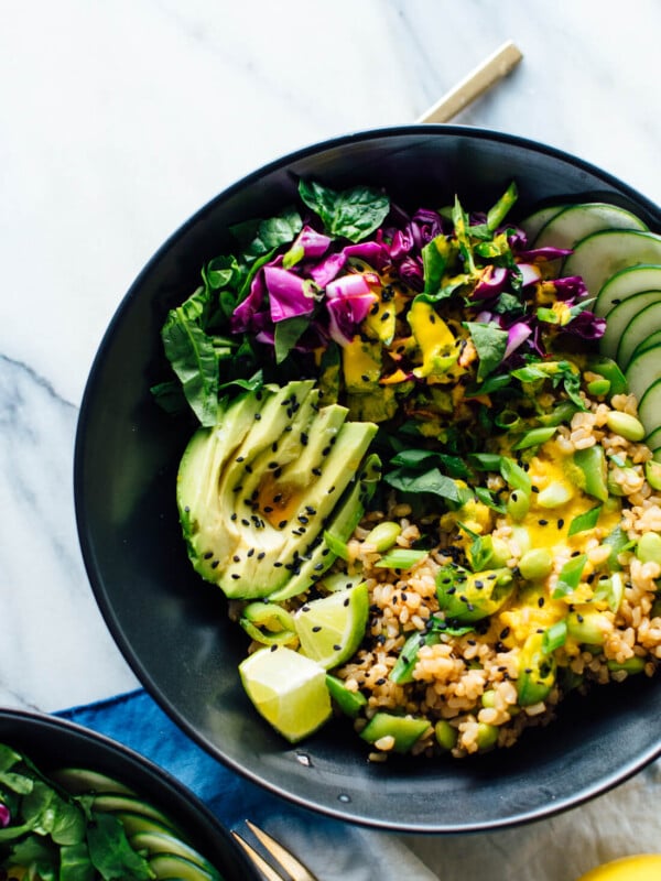 The ultimate Buddha bowl recipe, featuring cooked brown rice, steamed and raw veggies, avocado and an addictive carrot-ginger sauce. #vegan #vegetarian